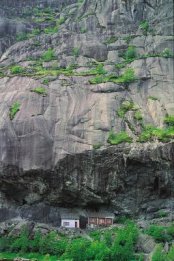 Foto van 2 huisjes onder een overhangende bergwand in Helleren, Zuid-Noorwegen